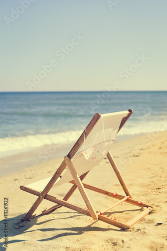 Deckchair and female hat on stunning tropical beach vacation background © aquar