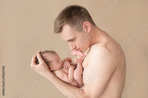 sleeping newborn baby in the father's arms