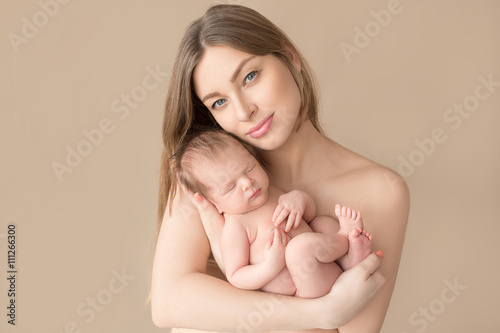 sleeping newborn baby in the mother's arms
