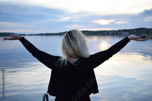 Young blonde woman with beautiful swedish landscape in the background