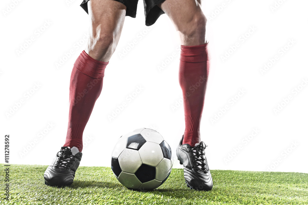 football player in red socks and black shoes running and dribbling with the ball playing on grass