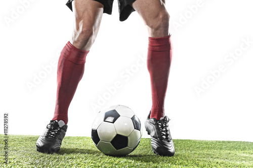 football player in red socks and black shoes running and dribbling with the ball playing on grass © Wordley Calvo Stock