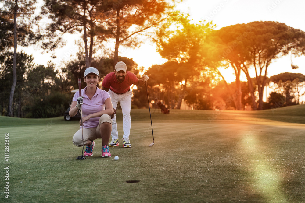 Fototapeta premium couple on golf course at sunset