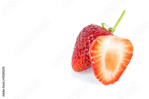 Strawberries and cut strawberry on white