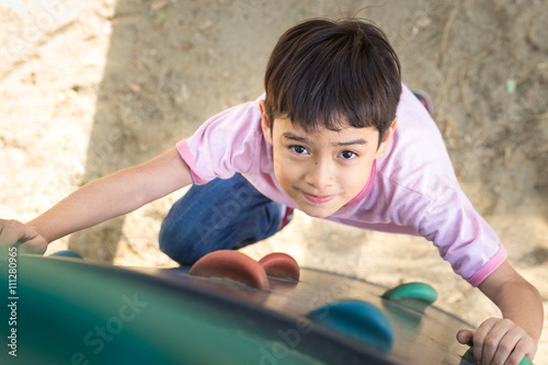 Little boy climbing up brave at playground