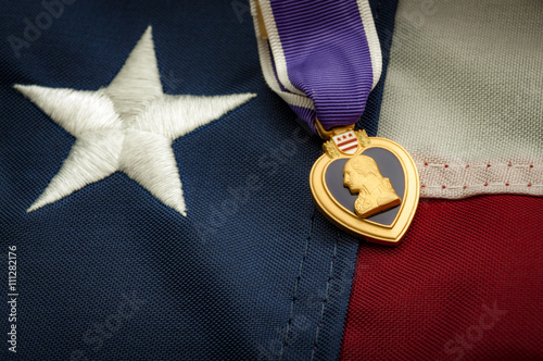 The Purple Heart is a United States military decoration awarded in the name of the President to those wounded or killed while serving and the american flag photo