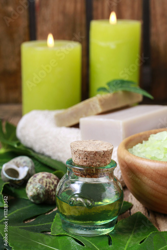 Bottle of green essential oil and scented candles