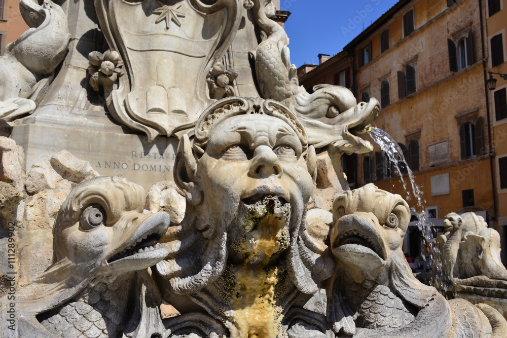 Grotesque marble head among strange fish, from the Fountain of the Pantheon, designed by Giacomo della Porta in 1575, in the center of Rome