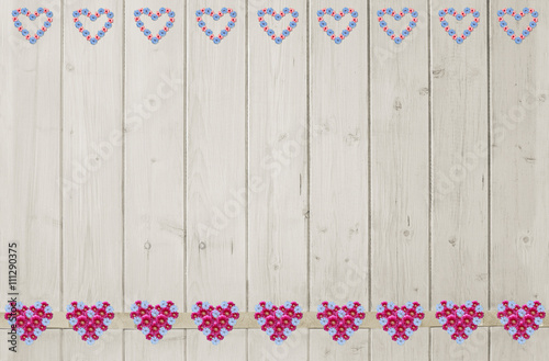 Holzwand mit Bordüre aus Blumenherzen