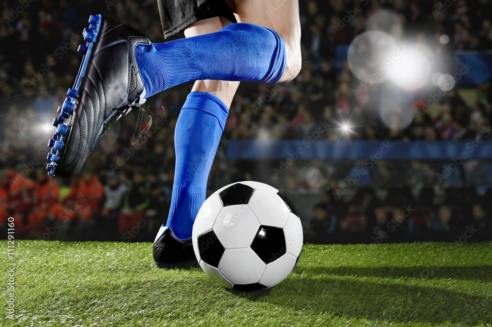 Fototapeta premium football player in action running and dribbling at soccer stadium playing match