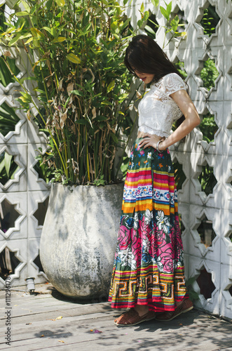 A lady with colorful skirt at the white corner 