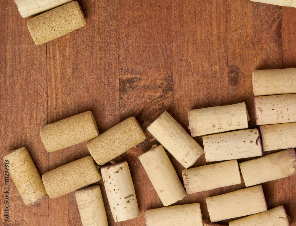 Fototapeta premium Many wine corks on dark brown wooden background texture