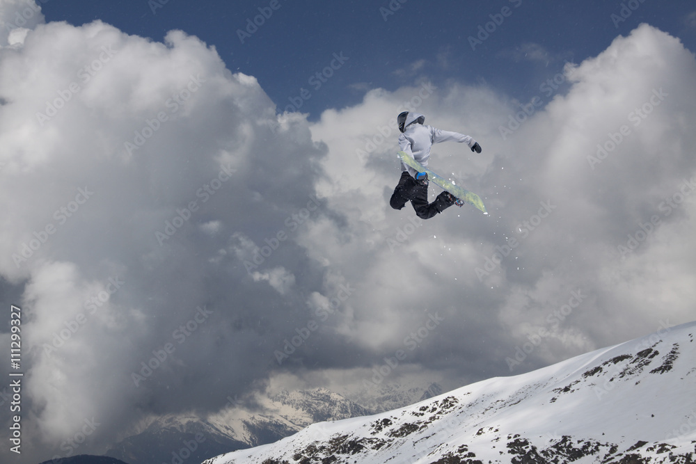 Snowboard rider jumping on mountains. Extreme snowboard freeride sport.