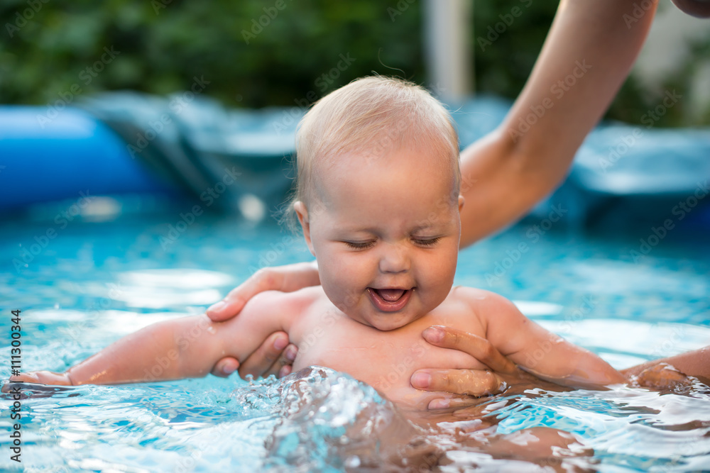 A cute happy young female girl child baby relaxing on the side of a swimming pool A cute happy young female girl child baby relaxing on the side of a swimming pool