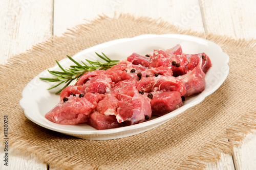 preparation of raw deer goulash with rosemary, peppercorn