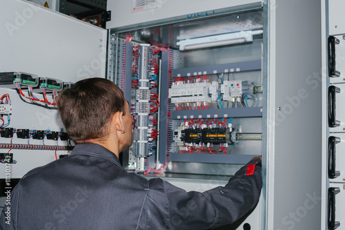 Electrician near the low-voltage cabinet. Uninterrupted power supply. Electricity.
