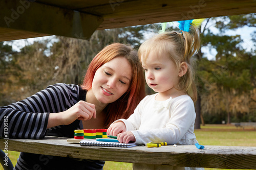 Mother and daughter drawing colors in a park photo