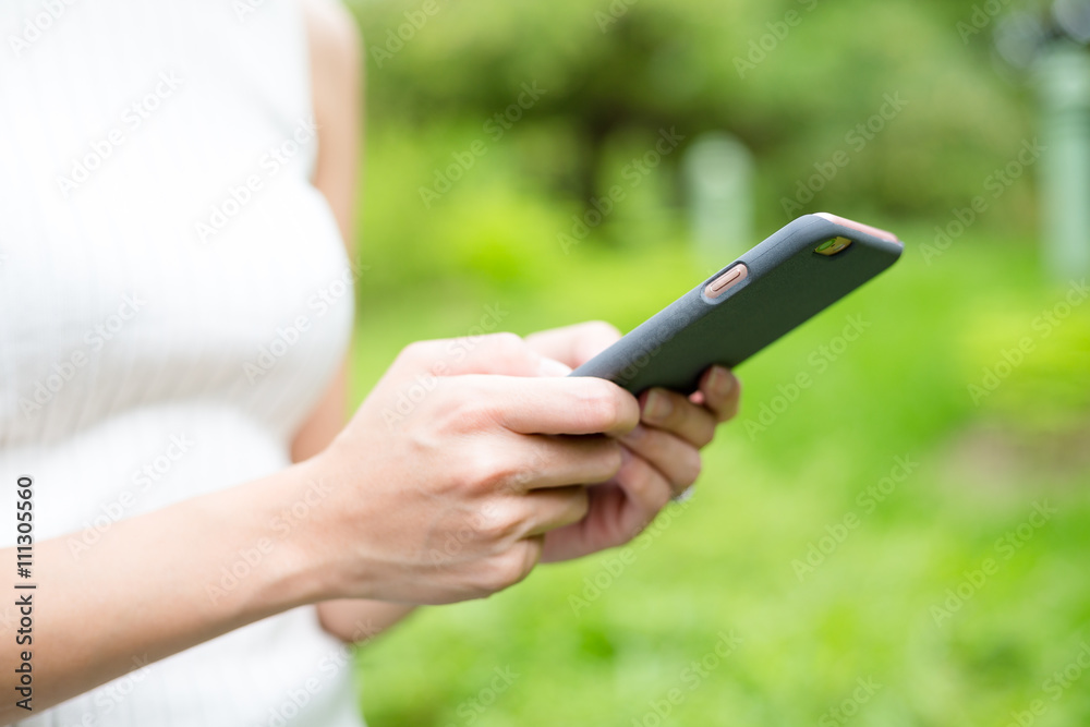 Woman using mobile phone at park