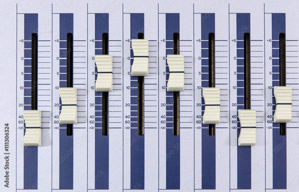 top view closeup of music mixer knobs in a metallic casing forming a wave curve
