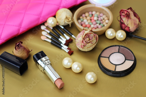 Cosmetics set for makeup and decorations on the gold background