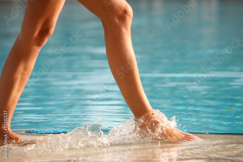 jambes de femme qui marche dans une piscine