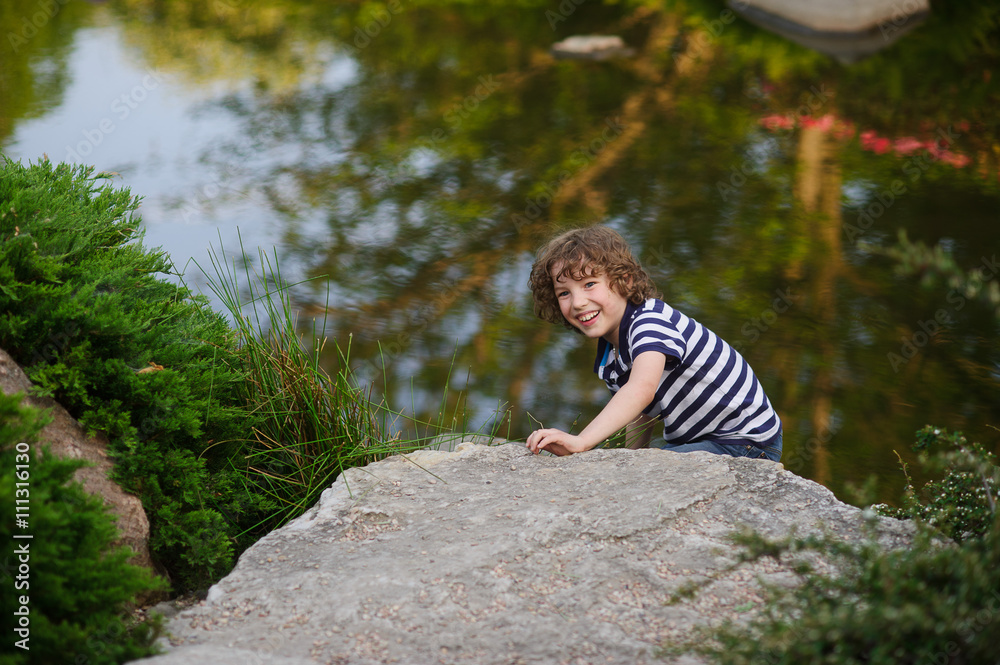 Naklejka premium Cheerful boy playing on the lake
