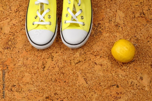 yellow sneakers on a background of cork