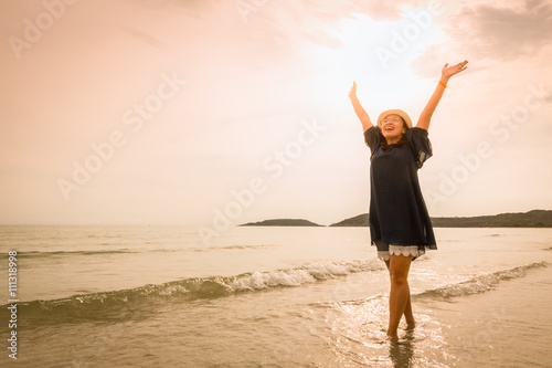 Happy young woman relaxing on beach (tone color photo)
