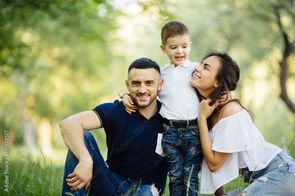 Ypung happy family spending their time in park  on picnic