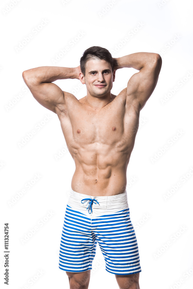 Portrait of a handsome young muscular man in swimwear with hands folded over his head isolated on white background