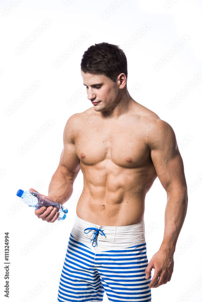 Young strong athlete on light background looking to the camera and smiling. Young strong athlete on light background looking to the camera and smiling.