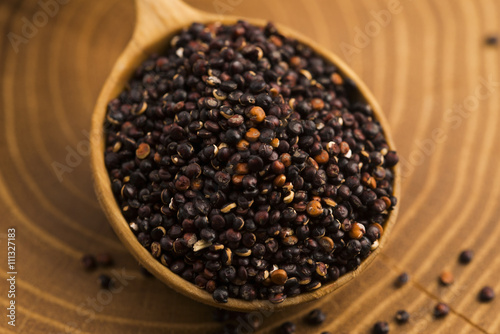 Black quinoa seeds on a wooden background