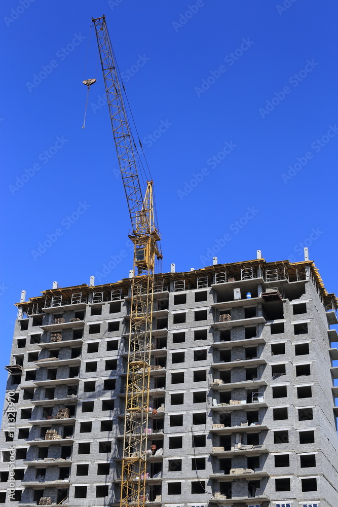 build tall buildings for residents. standing next to a construction crane. blue sky
