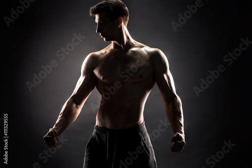 Sexy shirtless bodybuilder posing,