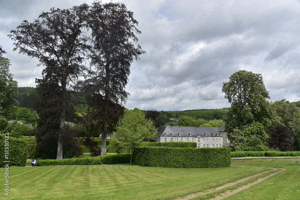 Obraz premium Le haut des Jardins d'Eau d'Annevoie avec le château de Rouillons en contre-bas sous un ciel chargé