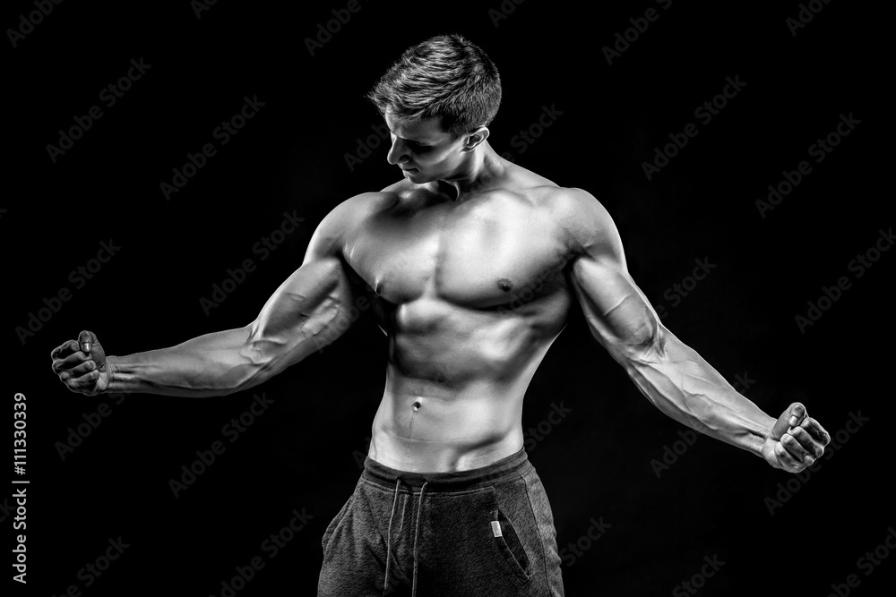 Fototapeta premium Stunning muscular man showing perfect abs, shoulders, biceps, tr