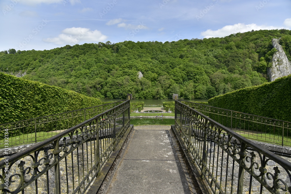 La passerelle rustique séparant le pavillon rococo et le jardin au château de Freyr à Hastière