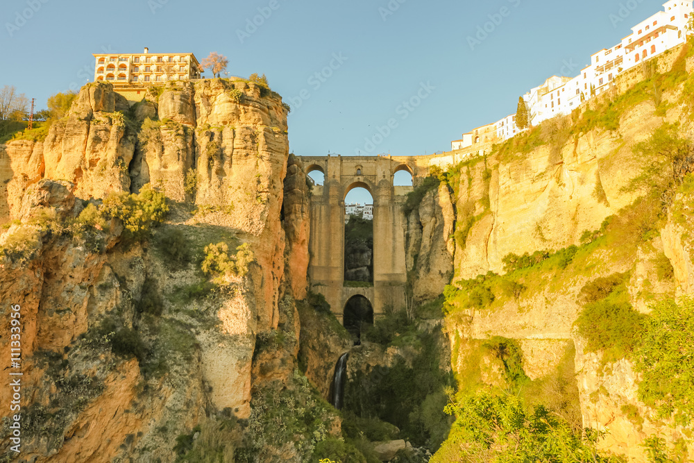 The popular historic landmark of spectacular Puente Nuevo, New Bridge, at sunset over Guadalevin River in town of Ronda, Andalusia, Spain.
