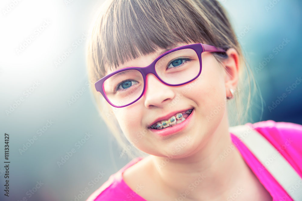 Fototapeta premium Girl. Teen. Pre teen. Girl with glasses. Girl with teeth braces. Young cute caucasian blond girl wearing teeth braces and glasses.