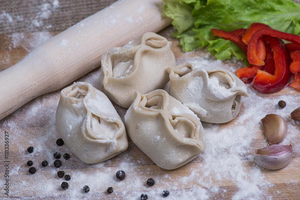 raw dumpling on bamboo wickerwork with flour and pepper