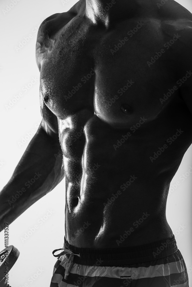 Side-view silhouette of young muscular athletic sexy shirtless hot man  posing showing sport body with cool pectoral abs muscle strong breast  biceps studio black and white. Beads sweat training gym. Stock Photo