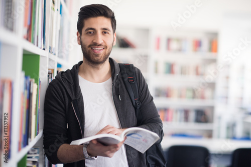 Tableau sur toile portrait of student while reading book  in school library