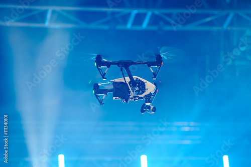 Drone flies over stage/Professional quadrocopter with video camera soars over the stage
