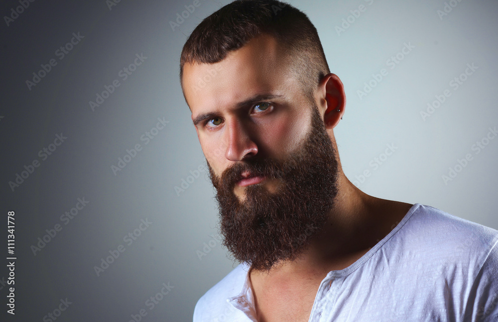 Obraz premium Portrait of handsome bearded man standing, isolated on grey bac