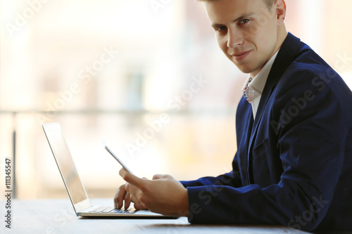 Man using laptop and smart ...