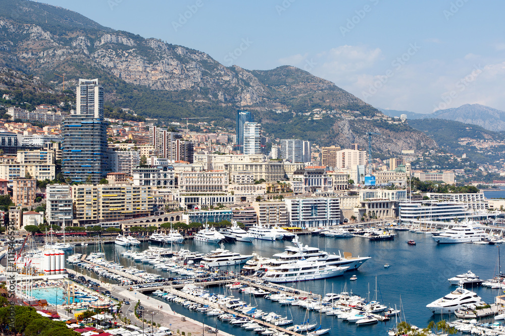 Monte Carlo harbor with luxury yachts and the city skyline in the background