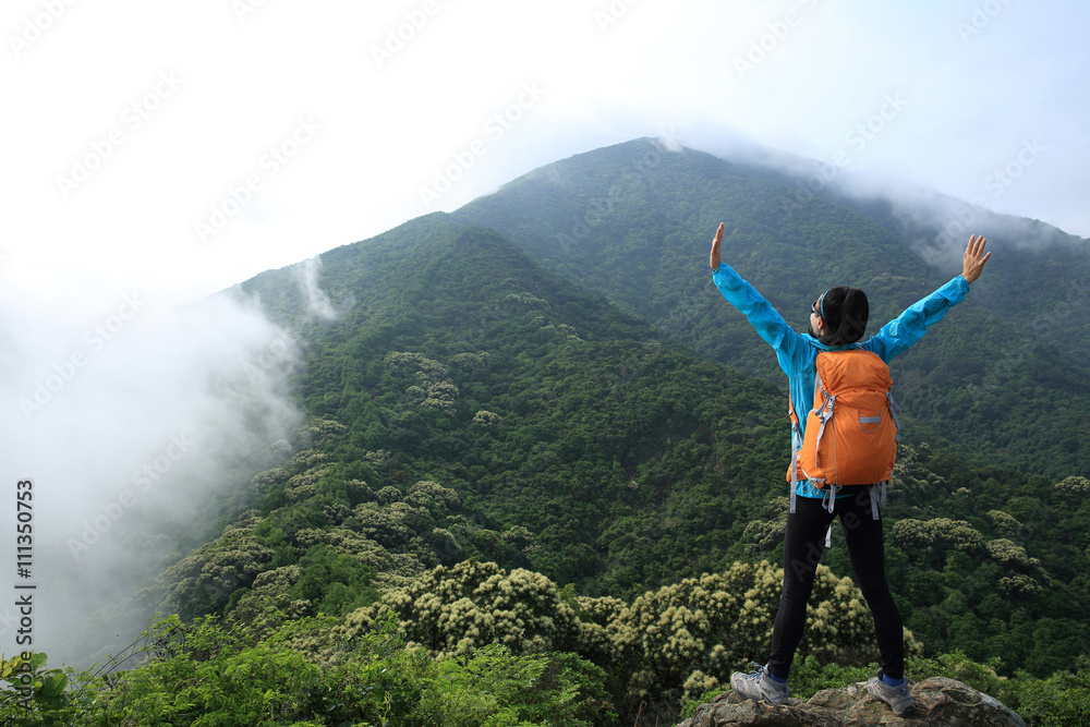 cheering young  woman enjoy the view on mountain peak