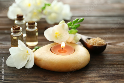 Spa set with sea salt, flowers and candles on wooden background