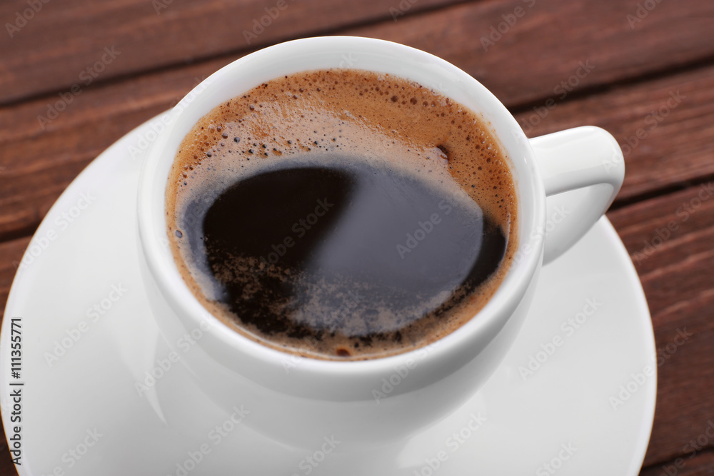 Cup of coffee with brown foam on wooden background, close up Cup of coffee with brown foam on wooden background, close up