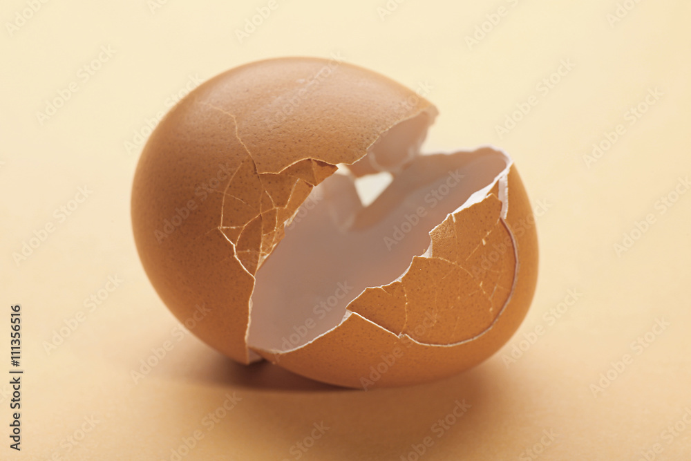 Broken egg on dark beige background Broken egg on dark beige background